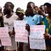 People hold signs during an anti-colonial demonstration against the regional CFA franc on the Place de l'Obelisque in Dakar on September 16, 2017. 
The CFA franc, which is pegged to the euro, is used in eight West African countries in the region, six of which are former French colonies. / AFP PHOTO / SEYLLOU